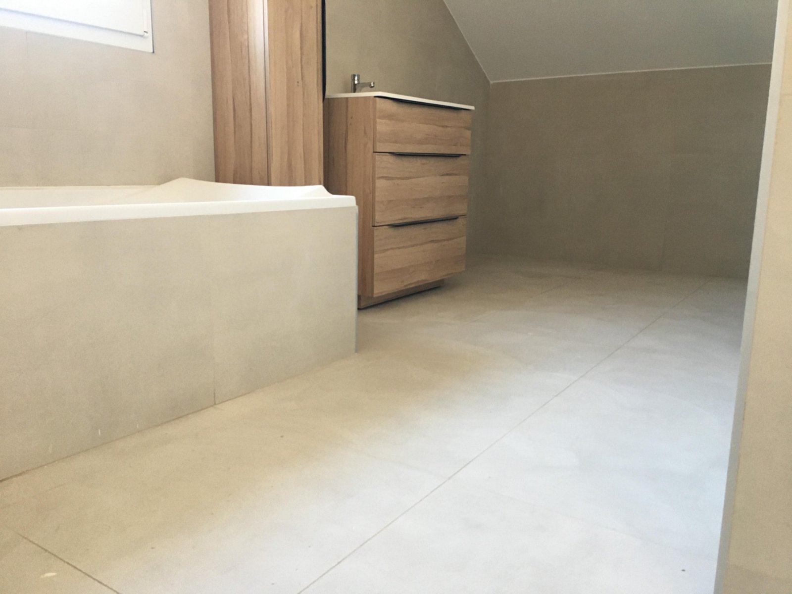 Salle de bain sous combles avec baignoire et meuble vasque bois
